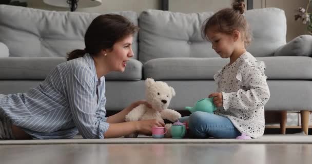Счастливая молодая заботливая мамочка играет в игрушки с маленькой дочерью. — стоковое видео