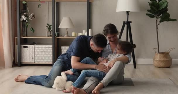 Feliz ligação jovem casal brincando com a filha do bebê pequeno. — Vídeo de Stock