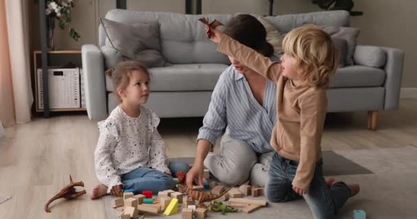 Glückliche junge Mutter spielt Spielzeug mit Kindern. — Stockvideo