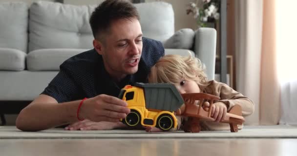 Liefdevolle jong zorgzame papa spelen speelgoed met kind zoon. — Stockvideo