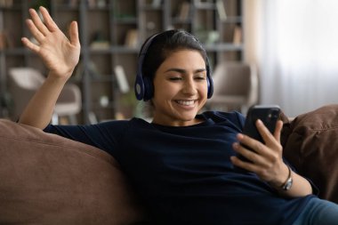 Gülümseyen Hintli kadın cep telefonuyla video görüşmesi yapıyor.