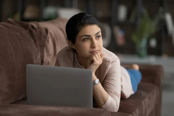 Pensive Indian woman relax on sofa dreaming — Stock Photo, Image