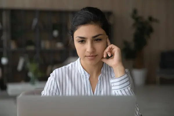 忧心忡忡的印度女人在笔记本电脑上思考 — 图库照片