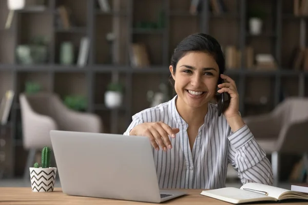 Glimlachende Indiase zakenvrouw raadplegen klant op mobiele telefoon — Stockfoto
