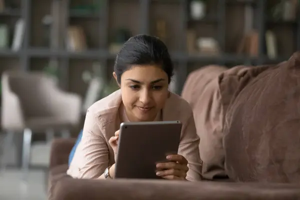 Mulher indiana relaxar no sofá usando tablet — Fotografia de Stock