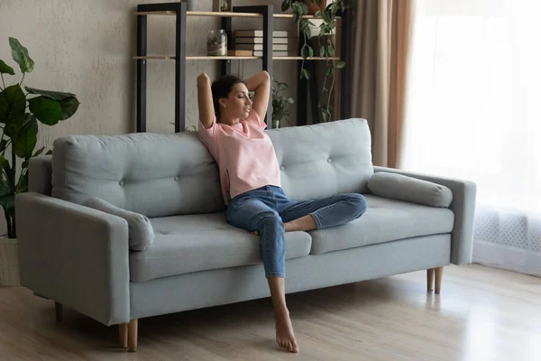 Serene arabian woman rest on sofa at home breath air — Stock Photo, Image