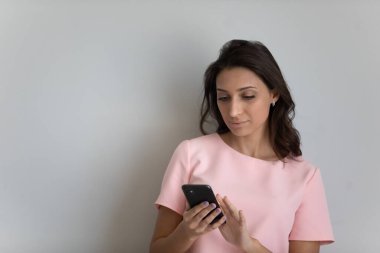 Modern milenyum Hindistanlı kadın cep telefonunu ekranlara bakarak kullanıyor.