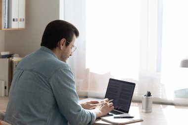 Bilgisayarda çalışan bir adamın arka görüntüsü