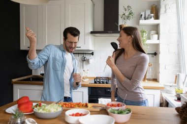 Mutlu milenyum çiftleri evde birlikte yemek pişirmenin tadını çıkarırlar.