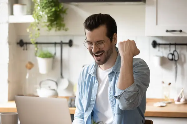 Emocionado homem milenar comemorar online loteria ganhar no laptop — Fotografia de Stock