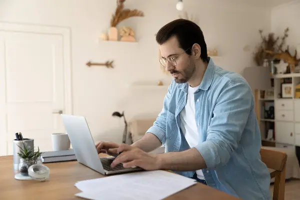Millennial man work distant on laptop from home