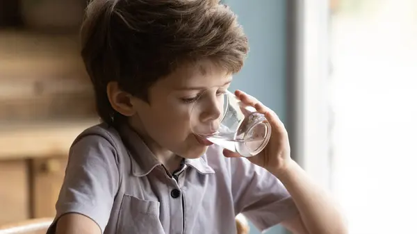 Närbild liten pojke dricka rent sötvatten, hålla glas — Stockfoto