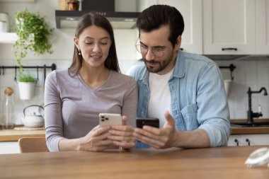 Mutlu çift evde akıllı telefonları kullanarak rahatlıyor.