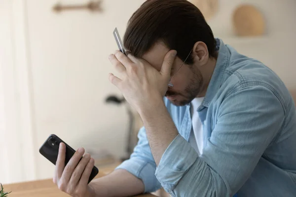 Unhappy man distressed with problems paying online on cell — Stock Photo, Image