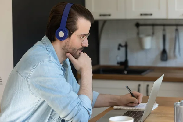 Homem caucasiano em fones de ouvido estudo on-line no computador — Fotografia de Stock