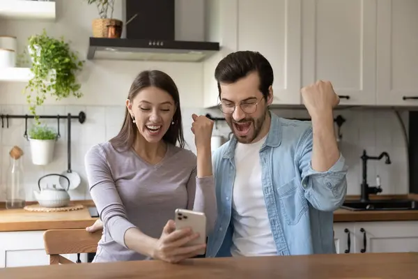 興奮したカップルは、携帯電話で勝つと陶酔感 — ストック写真