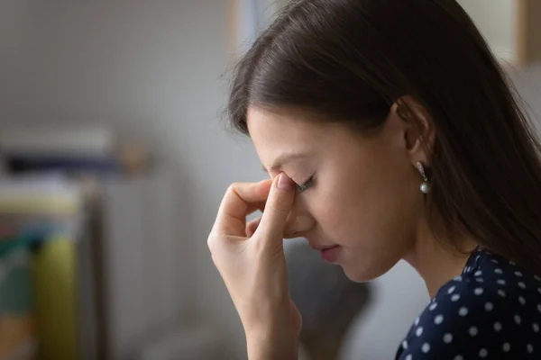 Mujer cansada sufre de migraña masajeando los ojos — Foto de Stock