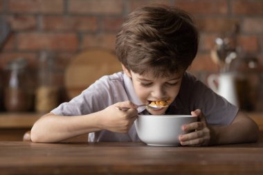 Tatlı mısır gevrekleri yiyen küçük mutlu çocuğu kapatın.