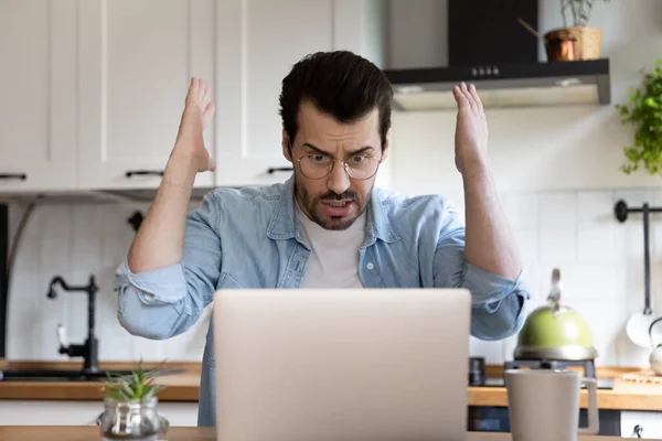 Hombre enojado mirar a la pantalla del ordenador portátil frustrado por el problema gadget — Foto de Stock