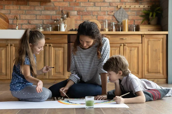 Zorgzame jonge moeder en twee kinderen spelen, schilderen aquarel — Stockfoto