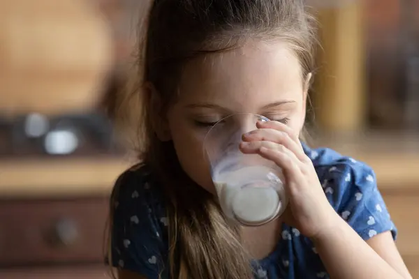 Close up cute little girl with closed eyes drinking milk — Stock Photo, Image