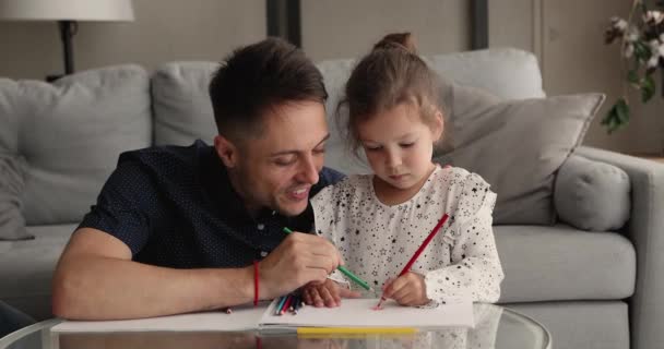 Zorgvuldige jonge vader onderwijzen klein schattig kind dochter tekening. — Stockvideo