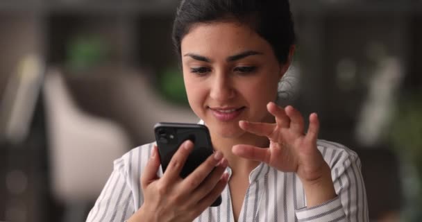 Sonriendo atractiva joven mujer étnica india utilizando la aplicación de teléfono inteligente. — Vídeos de Stock