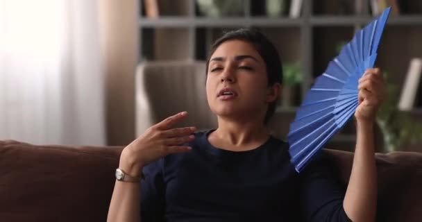 使用纸扇的沮丧的印度裔年轻妇女. — 图库视频影像