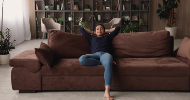 Young indian mixed race woman resting on comfortable sofa. — Stock Video