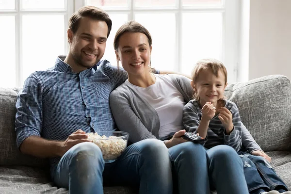 Feliz familia pareja con preescolar hijo niño viendo película — Foto de Stock