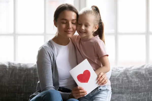 Feliz mamá agradecida sosteniendo tarjeta de felicitación con el corazón dibujado —  Fotos de Stock