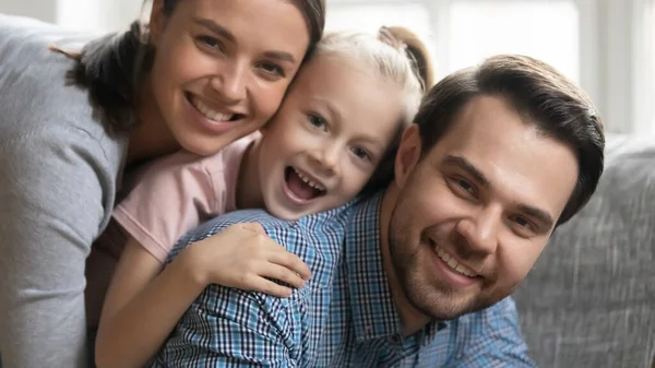 Retrato de linda familia feliz apilado en el sofá — Foto de Stock