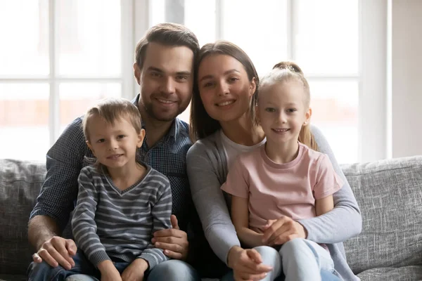 Ritratto di coppia di famiglia felice e bambini seduti sul divano — Foto Stock