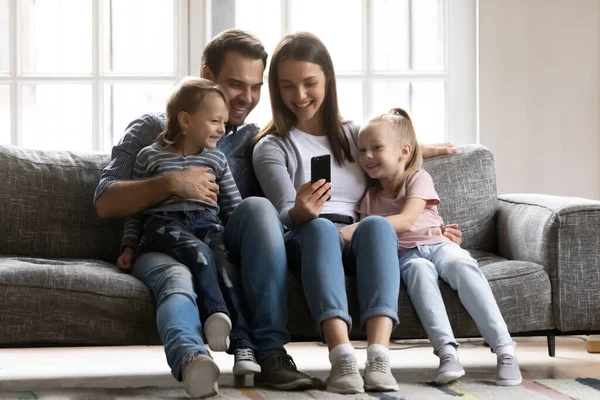 Gelukkig familie paar en kinderen spelen online spel — Stockfoto