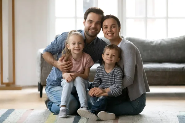 Portrait de couple millénaire tenant deux enfants d'âge préscolaire — Photo