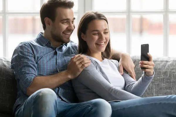 Glad tusenårig man och hustru med mobiltelefon — Stockfoto