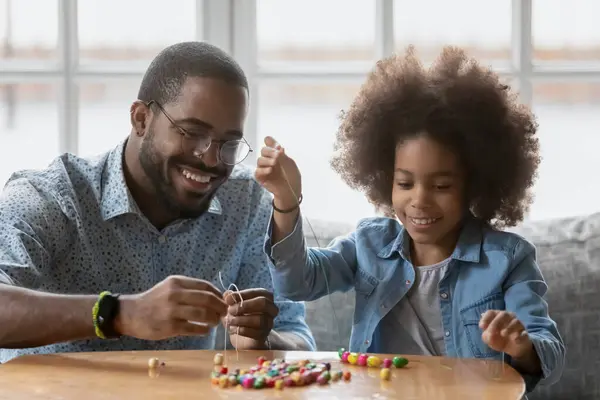 Feliz padre negro y niña haciendo decoración juntos —  Fotos de Stock