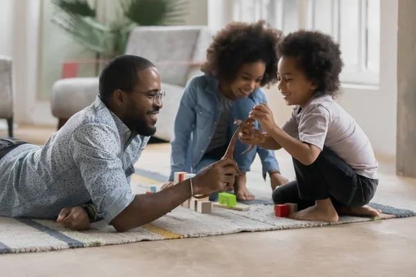 Szczęśliwy Afro amerykański tatuś i słodkie dzieci gry z zabawką — Zdjęcie stockowe