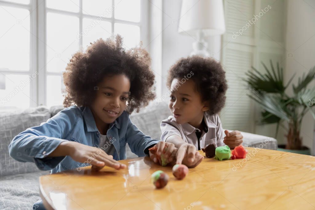Two cute Black kids practicing creative craft activity at home