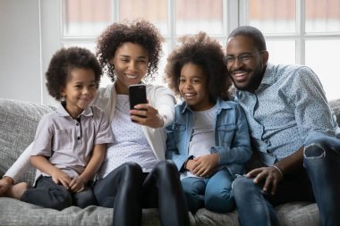 Mutlu siyah aile çifti ve iki çocuk selfie çekiyorlar.