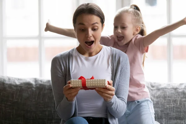 Emocionado niña hija dando caja de regalo de cumpleaños a mamá sorprendida — Foto de Stock