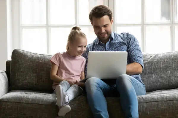 Feliz papá y lindo niño de la hija preescolar sentado en el sofá — Foto de Stock