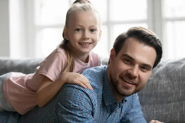 Portrait of cute girl lying on daddy back — Stock Photo, Image