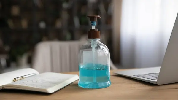 Close up of workplace with antibacterial sanitizer bottle