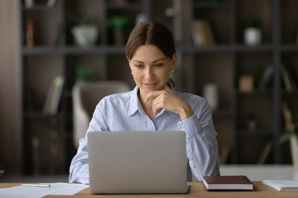 Lächelnde kaukasische Geschäftsfrau arbeitet im Homeoffice am Laptop — Stockfoto