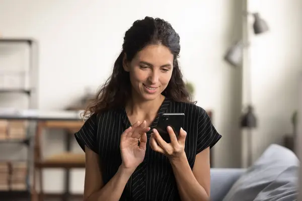 Zdjęcie głowy uśmiechnięta kobieta patrząc na ekran telefonu, trzymając smartfona — Zdjęcie stockowe