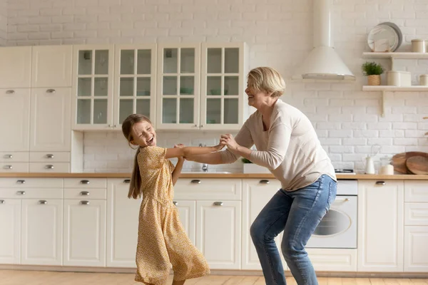 Aktive Senioren-Oma bringt kleinem Enkelkind in Küche das Tanzen bei — Stockfoto