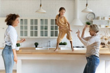 Enerjik anneanne kız evde komik bir partide dans ediyor.