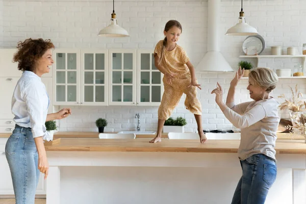Enerjik anneanne kız evde komik bir partide dans ediyor.