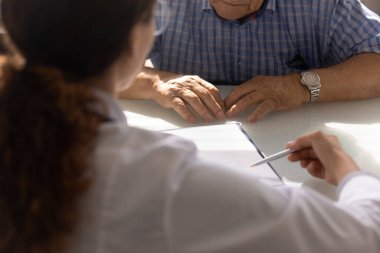 Doktor, olgun bir adama sağlık sigortası anlaşması hakkında danışmanlık yapıyor.